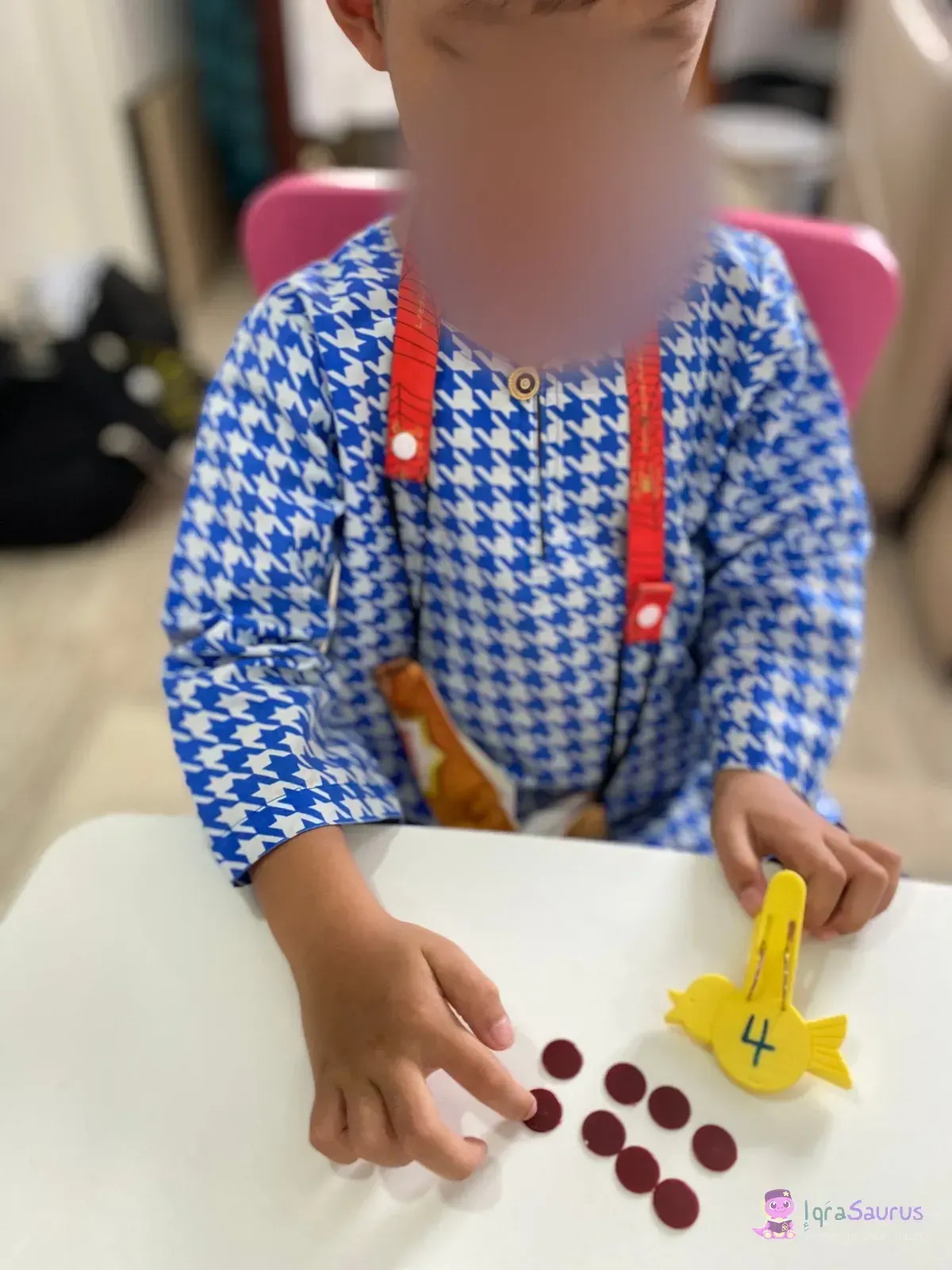 A child counting red counters beside the peg marked 4