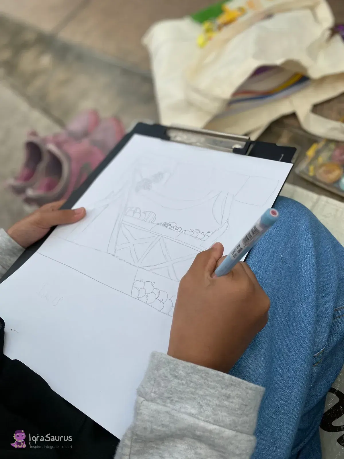 A child sketching a scene in pencil on a clipboard outdoors